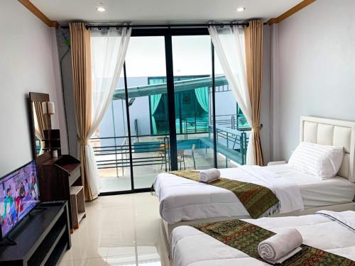 a hotel room with two beds and a television at Three Bridges Hotel in Nan