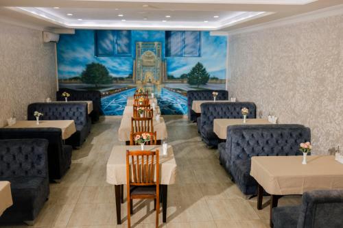 a restaurant with tables and chairs and a mural at Art Regency Premium Hotel, Free Airport Shuttle Service in Tashkent