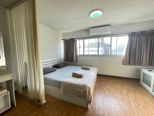 niewielka sypialnia z łóżkiem i oknem w obiekcie Popular The best muangthongthani 日常房间公寓 w mieście Ban Bang Phang