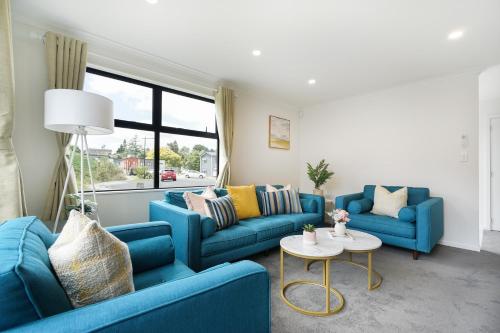 a living room with two blue couches and a table at Charming 4bds House with 3 bathrooms Brand New in Hamilton