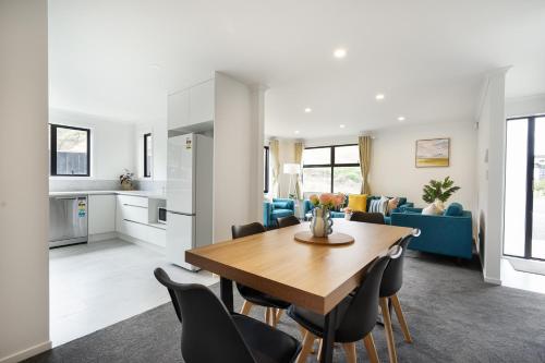 a kitchen and living room with a table and chairs at Charming 4bds House with 3 bathrooms Brand New in Hamilton
