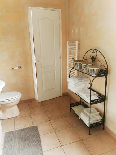 a bathroom with a toilet and a shelf with towels at jeanguy andrieu in Labruguière