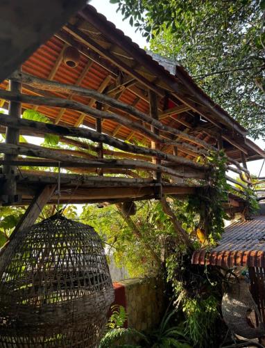 a wooden building with a roof and a bird cage at TARA LODGE Haven of peace in Kep