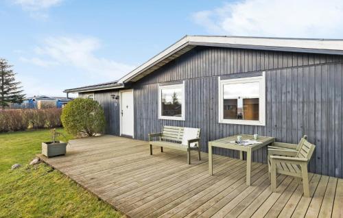 Una terraza de madera con dos sillas y una mesa. en Cozy Home In Glesborg With Kitchen, en Glesborg