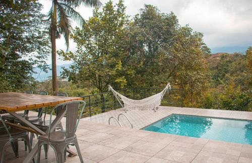 a patio with a table and a swimming pool at Villa Jenis By The Villas 100 in Bogor