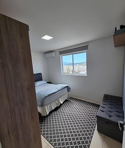 ein kleines Schlafzimmer mit einem Bett und einem Fenster in der Unterkunft PC803 - AP Grande, 1 Suíte, 1 Quarto, 90m2, até 6 pessoas in Balneário Camboriú