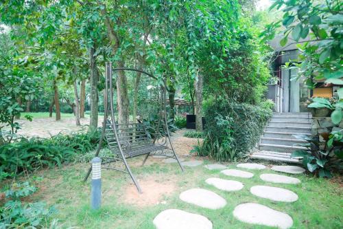 a swing in a garden with a tree at Villa Owner tại khu nghỉ dưỡng sinh thái Đại Lải Resort in Ngọc Quang