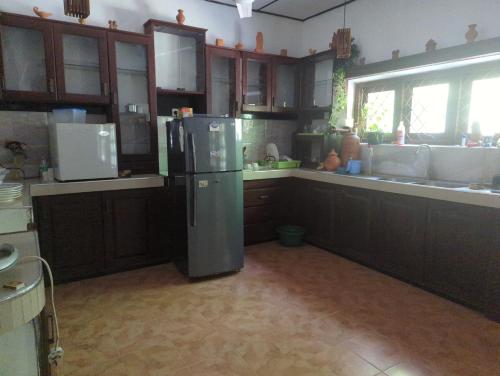 uma cozinha com um frigorífico no meio em The Traditional Villa by ceyio em Matara