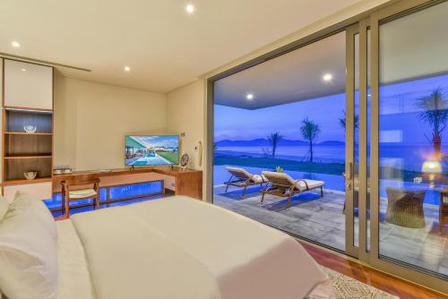 Dreamy Beach Villas And Resort في دا نانغ: غرفة نوم مع سرير وإطلالة على المحيط