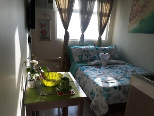 een slaapkamer met een bed met een tafel en een raam bij Para Sa'yo in Manilla