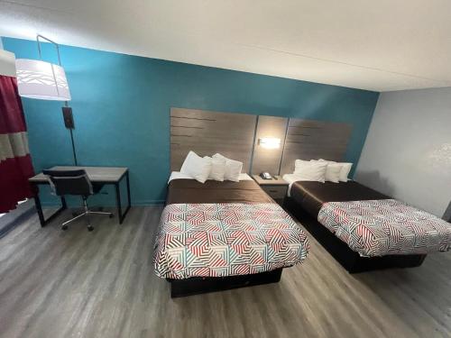 a hotel room with two beds and a desk at Jackson Motel in Murfreesboro
