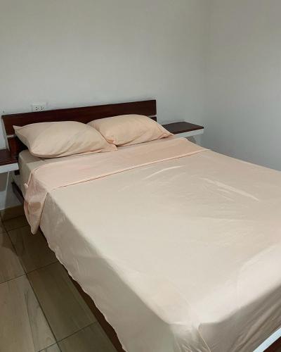 a large bed with white sheets and pillows at Olas inn in Asia