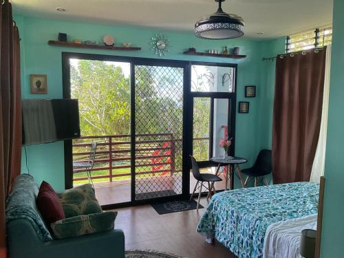 a bedroom with a bed and a sliding glass door at Anza Cabin at Threesome Cafe in Cebu City