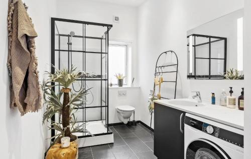La salle de bains est pourvue d'un lavabo et d'un lave-linge. dans l'établissement Cozy Home In Aakirkeby With Kitchen, à Vester Sømarken