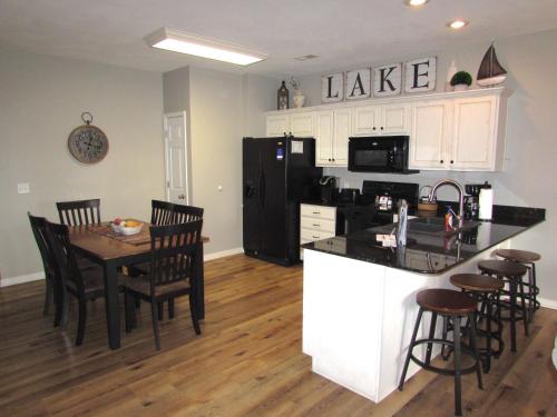 a kitchen with a table and a black refrigerator at Walk-in level Condo B-6 Near Lake in Hollister