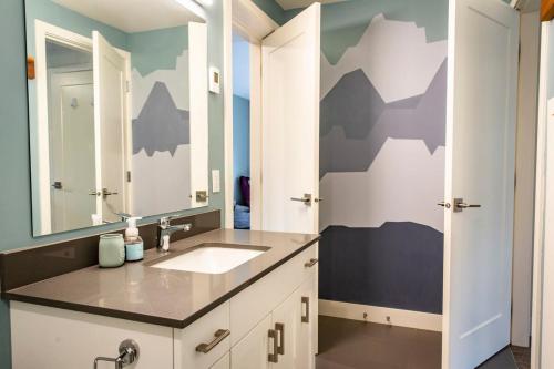 baño con lavabo y espejo grande en Suite Lines Revy - One Bedroom Near RMR en Revelstoke