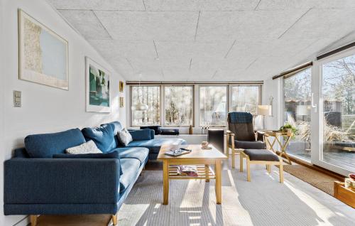 Una sala de estar con un sofá azul y sillas. en Lovely Home In Sæby With Wifi, en Saeby