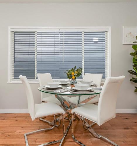 a dining room with a glass table and white chairs at La Maison in Vancouver