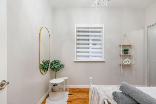 um quarto branco com um espelho e uma cama em La Maison em Vancouver