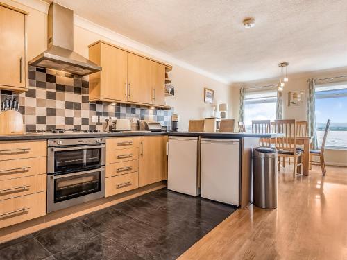 a kitchen with stainless steel appliances and a table at Dunlin Haven in Sandside
