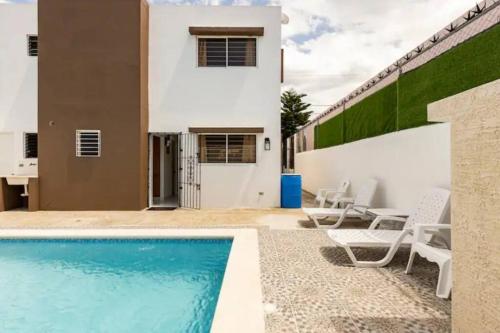 ein Pool vor einem Haus in der Unterkunft Villa Portes Pop in San Felipe de Puerto Plata