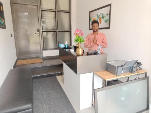 a man standing at a counter in an office at Devaki Resort in Pondicherry