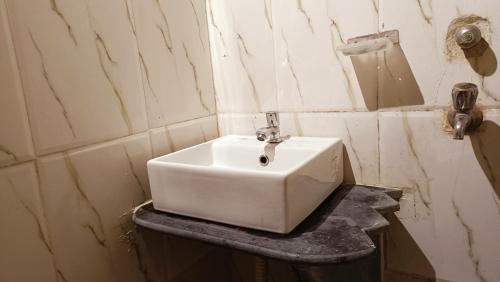 - un lavabo blanc sur un comptoir dans la salle de bains dans l'établissement NIRMAN HOMESTAY 5 minutes walk to beach, à Purî