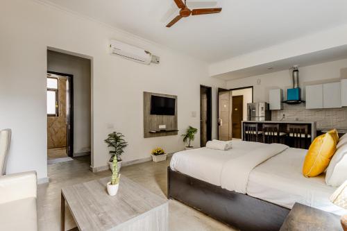 a bedroom with a large bed and a kitchen at Lime Tree Hotel - Golf Course Road, Sector-43, Gurugram in Gurgaon