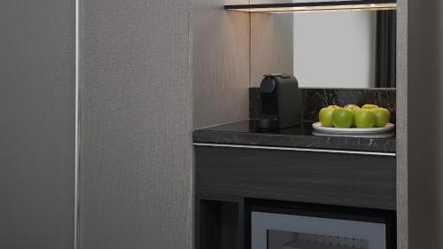 a hotel room with a plate of green apples on a counter at Courtyard by Marriott Brisbane South Bank in Brisbane