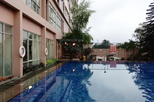 einem Pool vor einem Gebäude in der Unterkunft Apartement Studio The Edge Baros by Sky in Cimindi