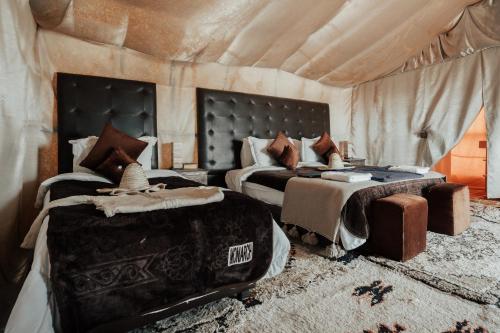 a bedroom with two beds in a tent at Family Luxury Glamping in Merzouga