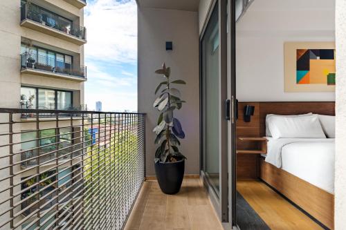 - Balcón con cama y maceta en Lumina at Taman Condesa, en Ciudad de México