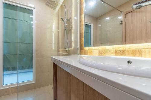 a bathroom with a sink and a shower and a mirror at City Garden Tower 1 bedroom in Pattaya South