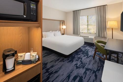 a hotel room with a bed and a television at Fairfield Inn & Suites By Marriott Alexandria in Alexandria