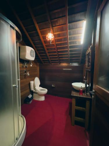 a bathroom with a toilet and a sink at Munduk Tjeraki House in Munduk
