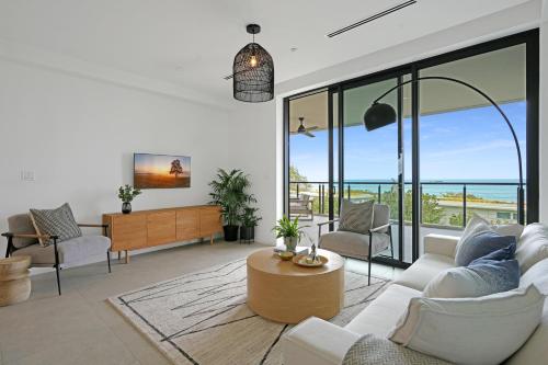 a living room with white furniture and large windows at VIDA Cayman Luxury Boutique Eco Hotel in West Bay
