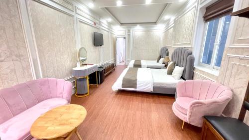 - une chambre avec un lit et deux chaises roses dans l'établissement BÔNG SEN HOTEL CÔN ĐẢO, à Côn Son