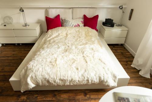 'Lady Hall' Guest House في Trotterscliffe: غرفة نوم بسرير ابيض ومخدات حمراء