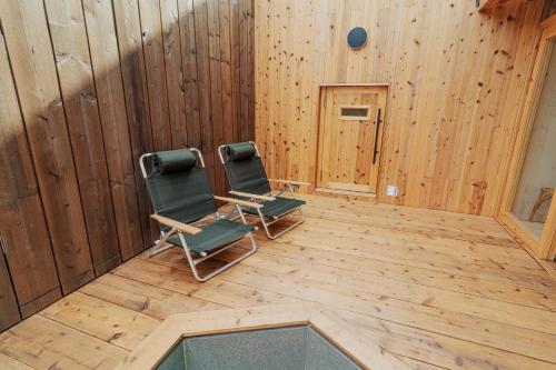 two chairs sitting in a room with wooden walls at 6ishiki in Kameoka