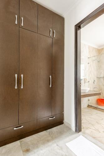 a bathroom with brown cabinets and a bath tub at Lime Tree Hotel - Golf Course Road, Sector-43, Gurugram in Gurgaon