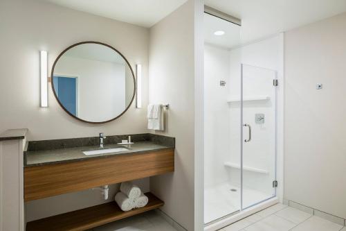 La salle de bains est pourvue d'un lavabo et d'un miroir. dans l'établissement Fairfield Inn & Suites by Marriott Des Moines Downtown, à Des Moines