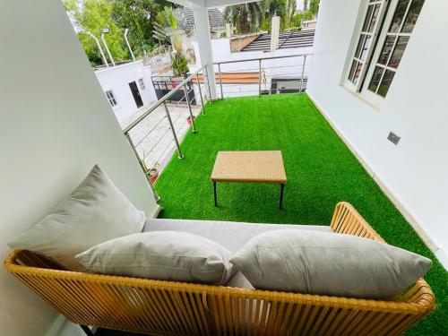 a balcony with a couch and a green lawn at Casa in Abuja
