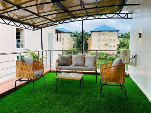 a patio with a couch and chairs on a balcony at Casa in Abuja