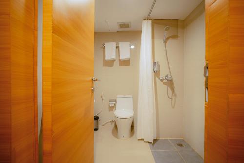 a bathroom with a toilet and a shower at Portola Arabia Hotel Banda Aceh in Banda Aceh