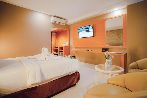 a hotel room with a bed and a tv at Portola Arabia Hotel Banda Aceh in Banda Aceh