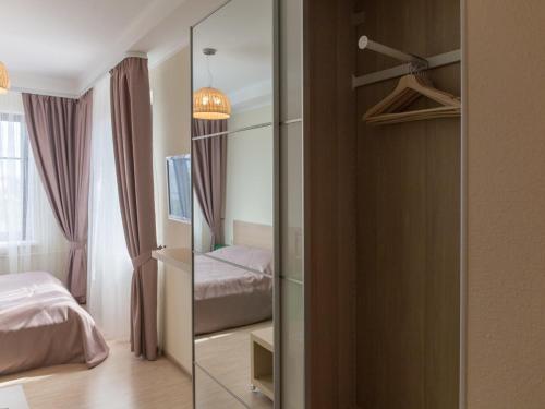 ペルミにあるGarni Apartments Sibiriaのベッドルーム(鏡、ベッド付)