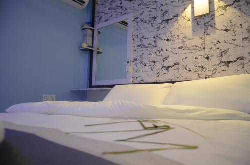 a bedroom with a white bed and a mirror at Isle inn {Fuvahmulah) in Fuvahmulah