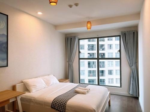 a bedroom with a bed and a large window at Saigon Royal in Ho Chi Minh City