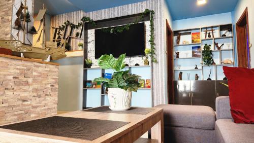 a living room with a couch and a tv at Isle inn {Fuvahmulah) in Fuvahmulah