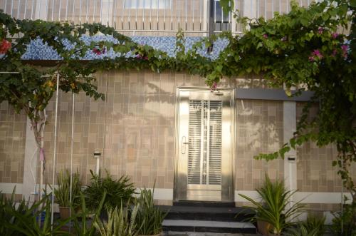 a door in the side of a building with plants at Isle inn {Fuvahmulah) in Fuvahmulah